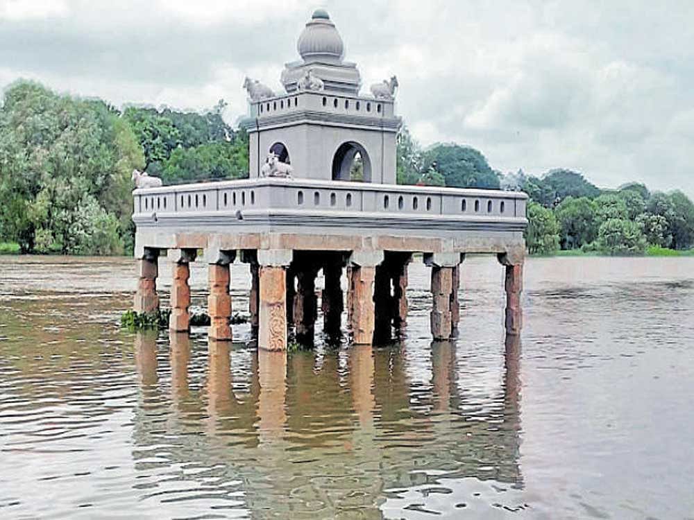 Hadinarukallu Mantap and the bathing ghat are partially submerged in swollen Kapila river following the release of water from Kabini reservoir in Nanjangud taluk on Sunday. dh photo