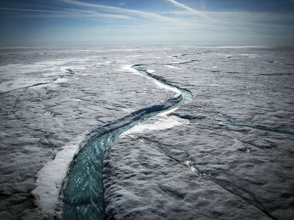 Meltwater flows along a supraglacial river on the Greenland ice sheet, one of the biggest and fastest-melting chunks of ice on Earth, on July 19, 2015. (CREDIT: Josh Haner/The New York Times)