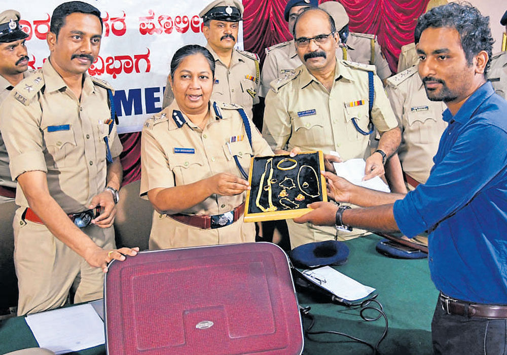 Additional Commissioner of Police (West) Malini Krishnamurthy and DCP&#8200;(South)&#8200;S&#8200;D&#8200;Sharanappa give away recovered stolen gold ornaments to rightful owner Vijay of Channammanakere Achchukattu on Wednesday. DH photo