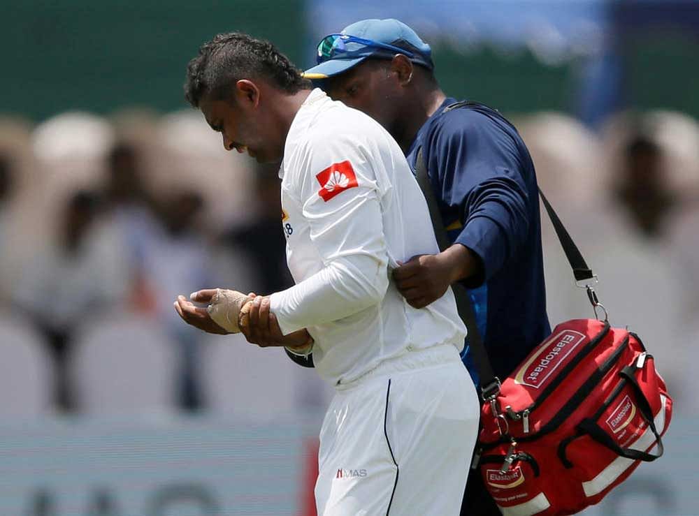 Sri Lanka's Asela Gunaratne leaves the ground after being injured. REUTERS