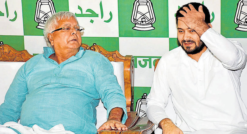 bihar in chaos: RJD Chief Lalu Prasad Yadav with his son and Bihar Deputy Chief Minister Tejaswi Yadav during a press conference in Patna on Wednesday. PTI