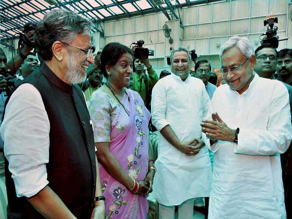 Nitish Kumar and senior BJP leader Sushil Kumar Modi share a lighter moment at an oath taking ceremony, at Raj Bhawan in Patna on Thursday. Kumar, who had yesterday resigned after falling out with RJD over alleged corruption charges against Lalu Yadav's son Tejashwi Yadav, was sworn-in as the Chief Minister of Bihar for the sixth time. Modi will be his Deputy Chief Minister. PTI Photo