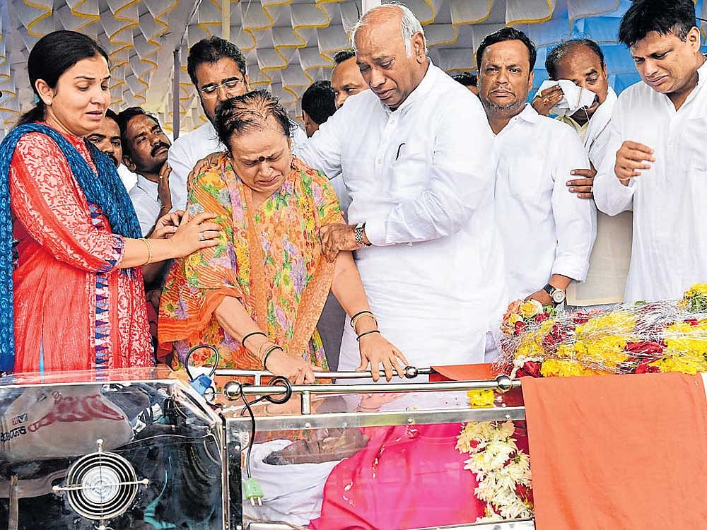 Congress leader Mallikarjun Kharge consoles the family of N Dharam Singh whose body was kept for public viewing at NV Grounds in Kalaburagi on Friday. Singh's wife Prabhavati, sons Ajay Singh and  Vijay&#8200;Singh are seen. DH&#8200;Photos