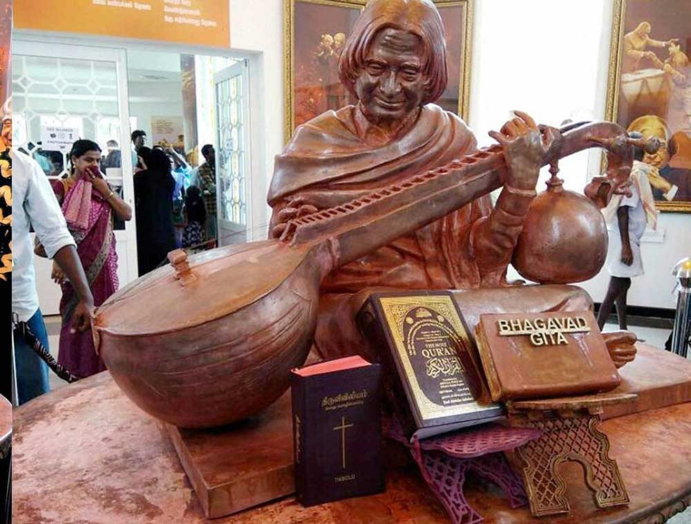 The copies of Bible and Quran placed along side a wooden piece engraved with the words 'Bhagavad Gita'? near the wooden statue of former president A P J Abdul Kalam, at his memorial in Rameswaram by one of his family members, on Sunday. The copies of Bible and Quran were placed after a row over the 'Bhagavad Gita'. PTI Photo