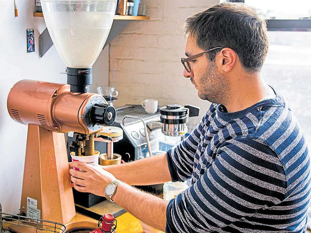 Cale Weissman, a freelance writer, tests a $2,700 Mahlkonig coffee grinder. INYT