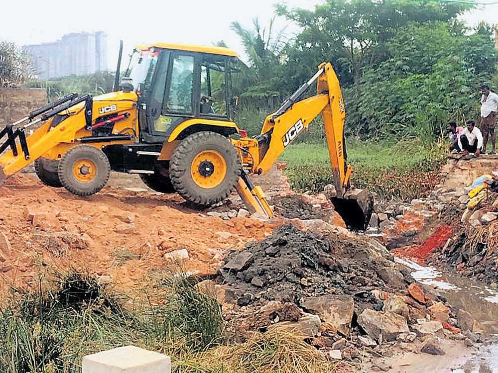 An earthmover has been pressed into service to clear the waterbody of garbage.