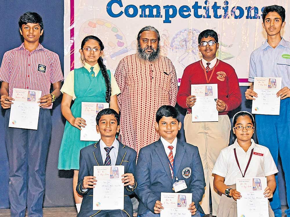 Quiz master Prof Arul Mani with the winners of the spelling bee competition organised by Deccan Herald in Education in Bengaluru on Wednesday. (Senior category winners: standing from left) Dejesh, St Joseph's Indian High School (consolation), Surabhi, Mary Immaculate School (third), Edward Zion Soji, Samuel Public School (second) and Aniruddha Halebid, Deccan International School (first). (Junior category winners: sitting from left) M V Aryan, BGS Public School, Kengeri (third), Tarun Gopal, BM English School (second) and Diya Agrawal, NPS (first). M Zaahid Yassin (not in picture), Army Public School, won the consolation prize. DH PHOTO