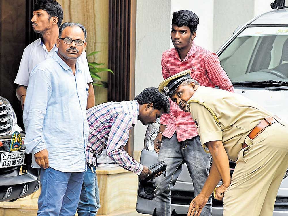 Police check a bag on the premises of Power Minister  D K Shivakumar's house during second day raids at Sadashivanagar in Bengaluru on Thursday. DH Photo