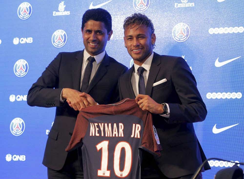 Brazilian soccer star Neymar holds his team shirt as he shakes with the chairman of Paris Saint-Germain Nasser Al-Khelaifi during a press conference in Paris. AP/PTI