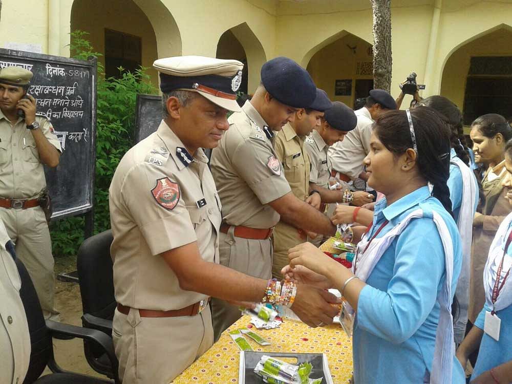 School girl tying Rakhi on the wrist of jaipur police commissioner Sanjay agarwal. DH Photo