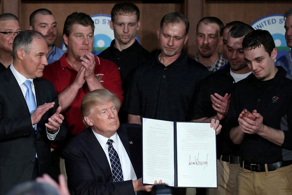 U.S. President Donald Trump holds up an executive order on 'Energy Independence,' eliminating Obama-era climate change regulations, during a signing ceremony at the Environmental Protection Agency (EPA) headquarters in Washington. Reuters file photo.