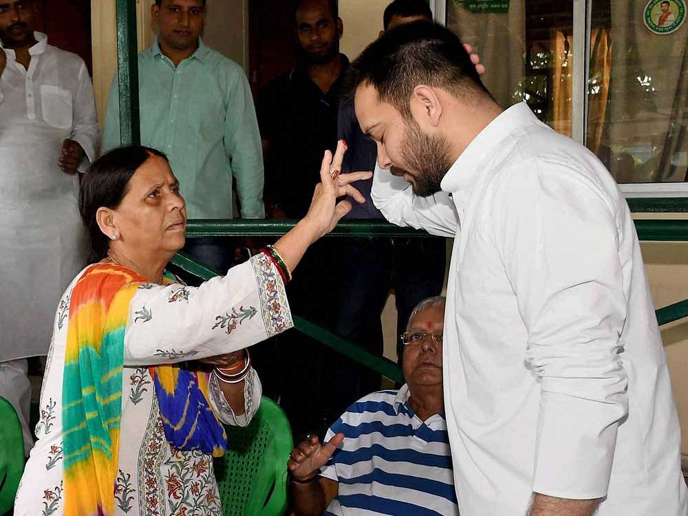 Senior RJD leader Rabri Devi applies 'tilak' on the forehead of former deputy chief minister of Bihar Tejaswi Prasad Yadav at their residence before the latter left for 'Janadesh Apaman Yatra', in Patna on Tuesday. PTI Photo