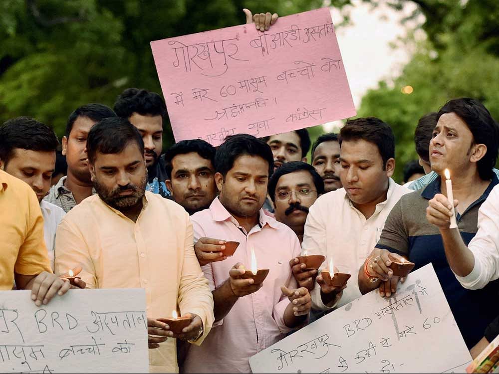 Youth Congress workers take part in a candle light march to pay homage to children who died at BRD Medical College at Gorakhpur, in New Delhi on Saturday. PTI Photo