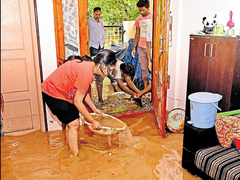 People drain water fromtheir house at S T Bed Layout.