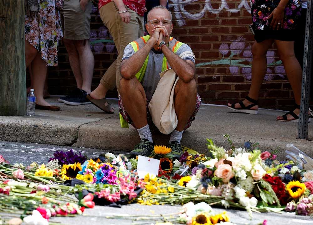 A man looks at flowers placed on the road of the site of the Charlottesville violence. Major industry faces have condemned the incident, and also quit a policy making body started by Trump after his muted response to the incident. Reuters file photo.