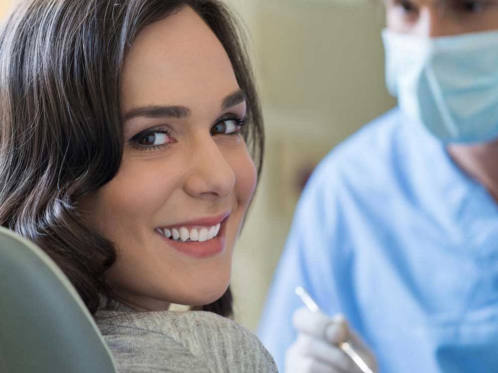 Smiling young woman receiving dental checkup  teeth