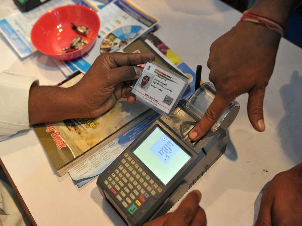 This file photo taken on January 18, 2017 shows an Indian visitor giving a thumb impression to withdraw money from his bank account with his Aadhaar or Unique Identification (UID) card during a Digi Dhan Mela, held to promote digital payment, in Hyderabad. India's Supreme Court ruled August 24 that citizens have a constitutional right to privacy, a landmark verdict that could have wide-reaching implications for the government's biometric programme which holds data on over one billion people.