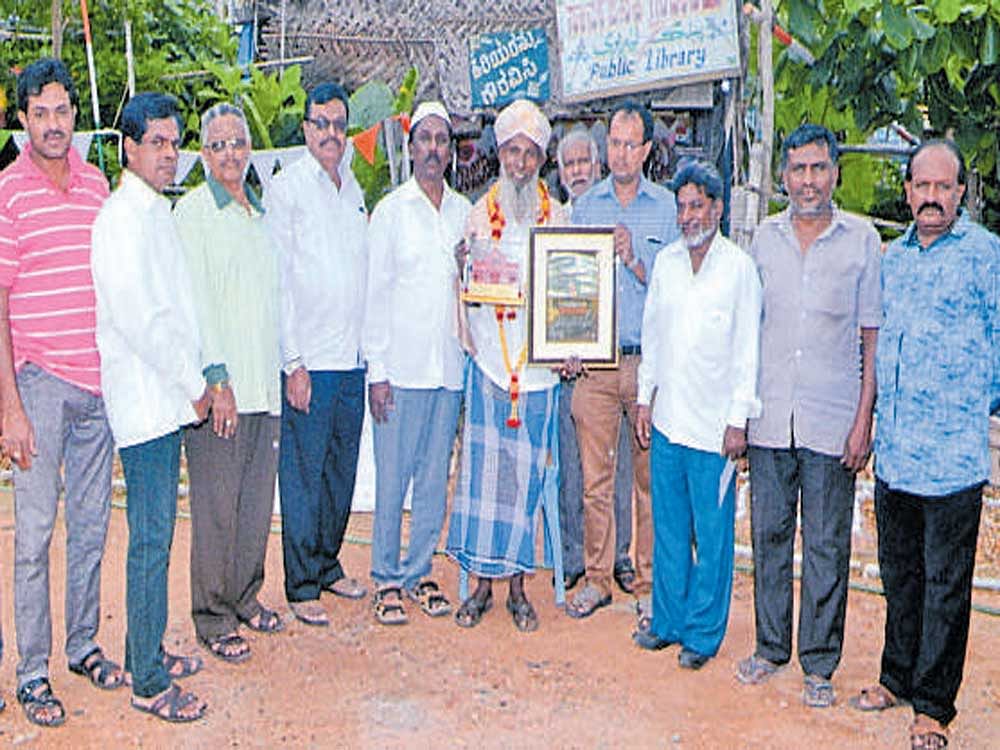Syed Ishaq being felicitated by like-minded people in front of his library at Rajeev Nagar, in Mysuru recently.