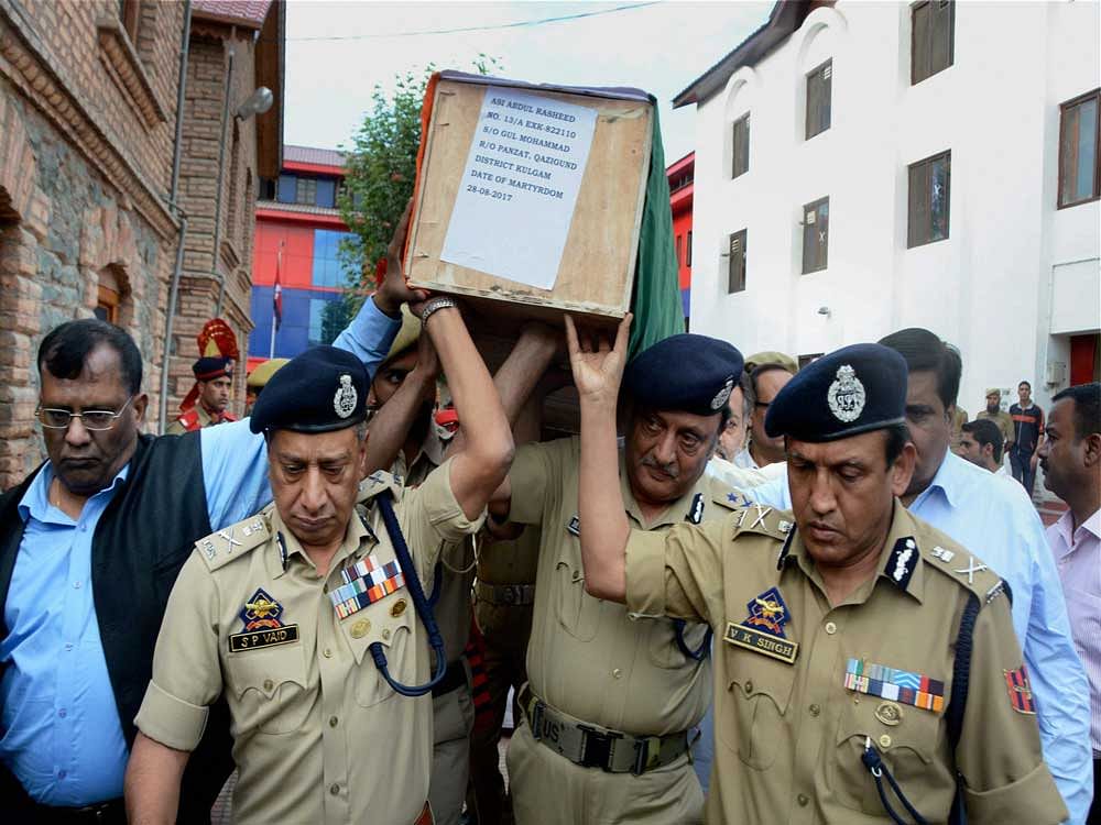 Director General of Jammu and Kashmir Police, SP Vaid along with other senior police officials carrying the body of police officer ASI Abdul Rashid who was shot dead by militants in an attack on a police party in Anantnag on Monday. PTI photo