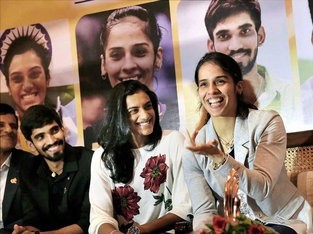 twin stars Saina Nehwal and PV Sindhu enjoy a light moment during a felicitation function on Thursday. PTI