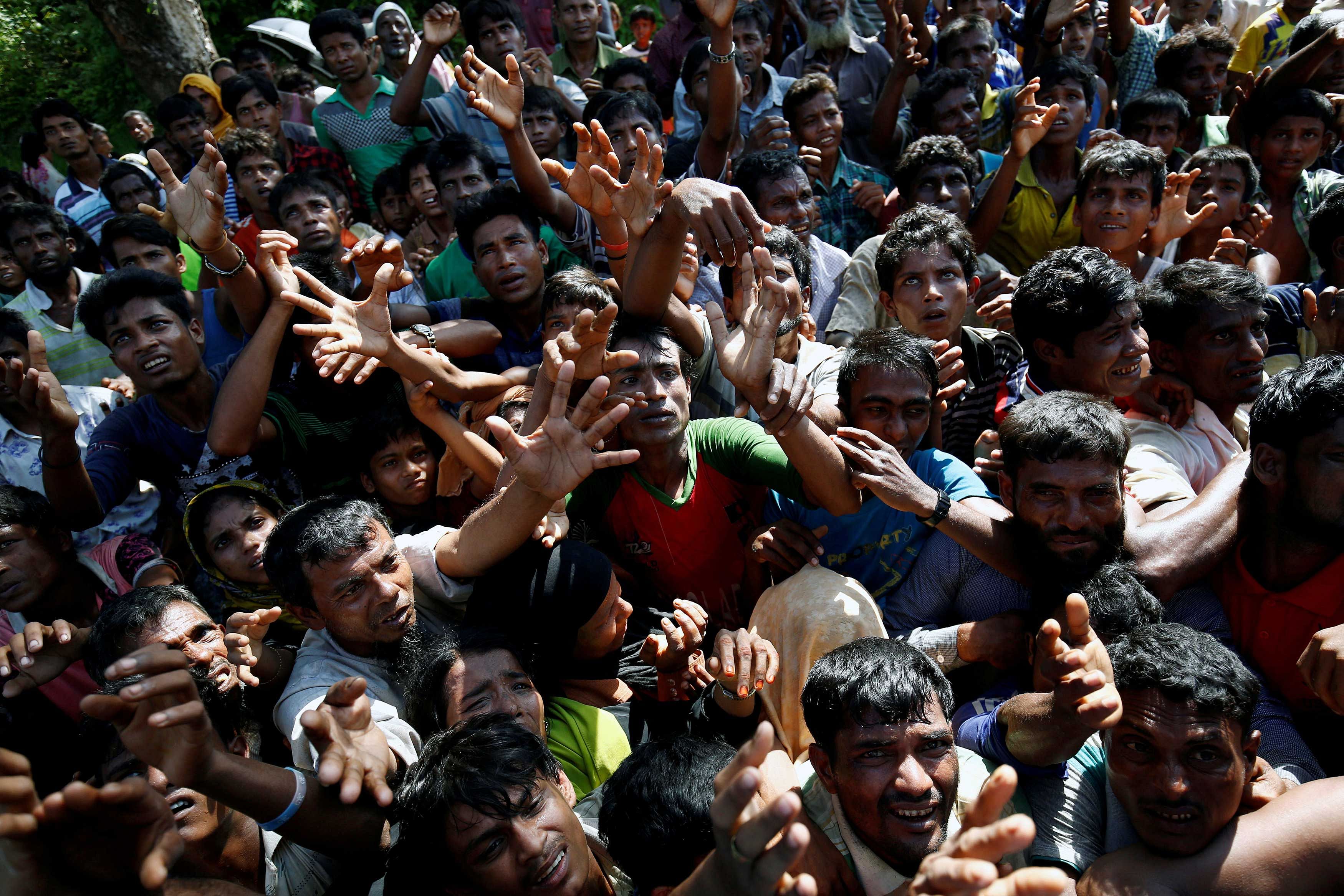 Rohingya refugees strech their hand for relief supplies given by local people in Cox's Bazar, Bangladesh. Reuters photo