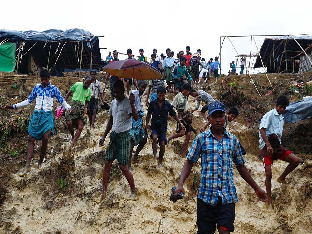 Rohingya refugees climb down a hill as it rains at a camp in Cox's Bazar, Bangladesh. Reuters Photo