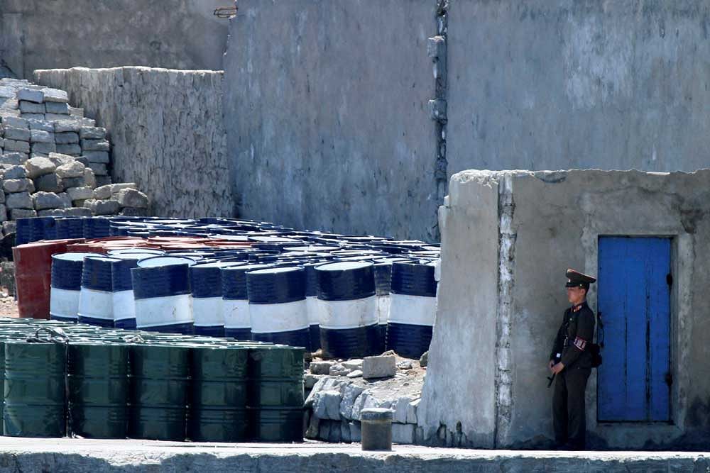AP/PTI file photo of a North Korean soldier standing by barrels of oil in Sinuiju, opposite to the Chinese city of Dandong. China has restricted trade with North Korea to comply with UN sanctions.