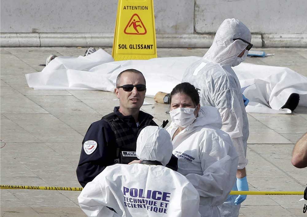 Investigative police officer work by a body under a white sheet outside Marseille 's main train station. AP,PTI Photo.
