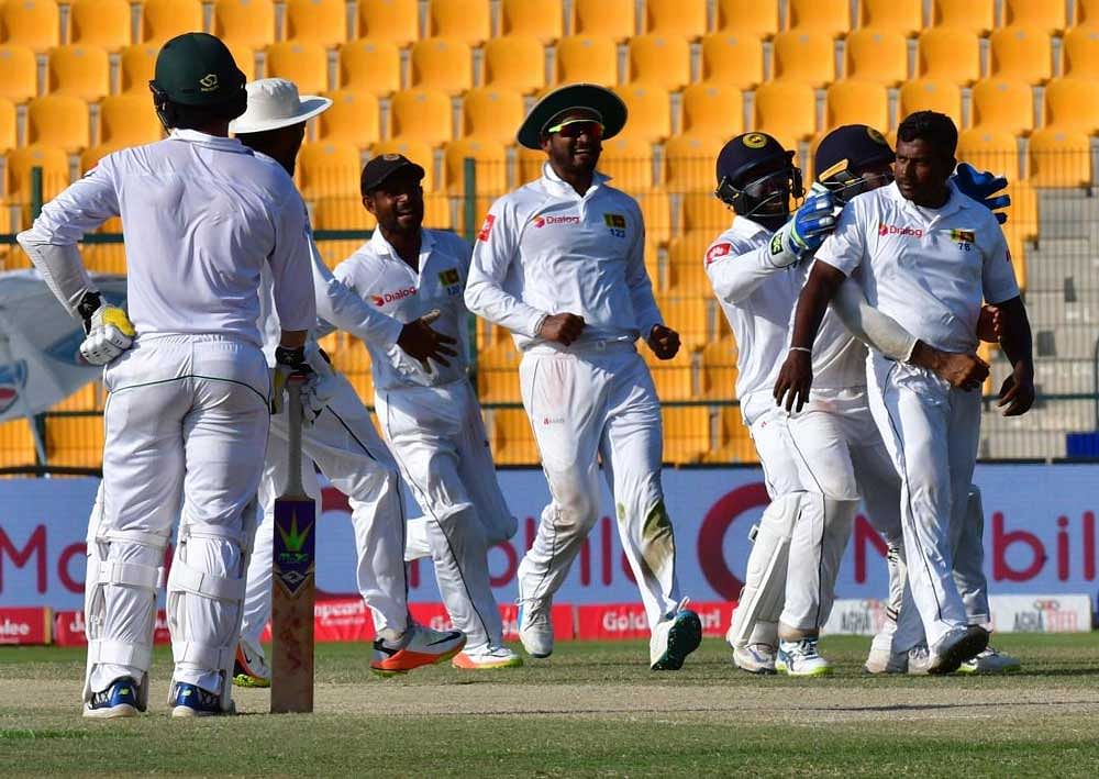 Milestone: Sri Lanka's Rangana Herath (R) celebrates after dismissing a Pakistan batsman on Monday. AFP