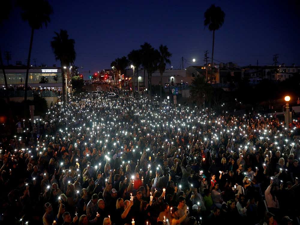 People hold candles and flashlights into the air during a memorial for Rachael Parker and Sandy Casey, Manhattan Beach city employees and victims of the October 1st Las Vegas Route 91 music festival mass shooting. Reuters Photo