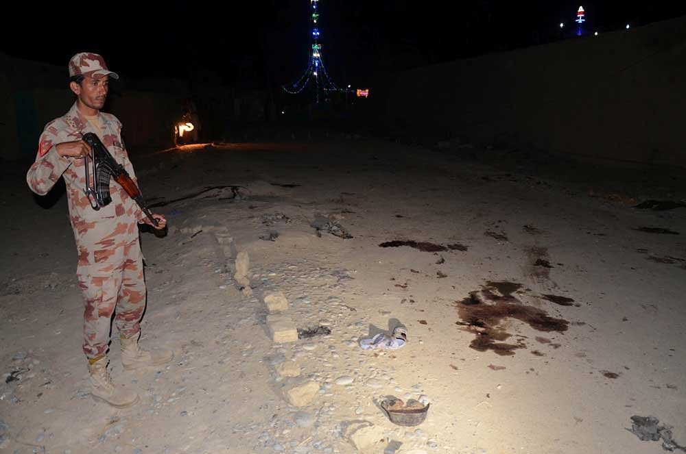 A Pakistani soldier stands guard after a suicide attack at a shrine in Pakistan. Reuters file photo.
