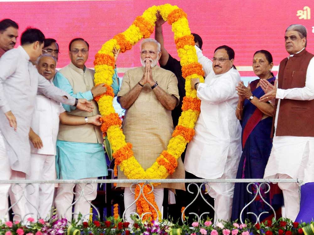 Prime Minister Narendra Modi being felicitated at a public meeting in his hometown Vadnagar on Sunday. Union Health Minister J P Nadda and Gujarat CM Vijay Rupani are also seen. PTI.