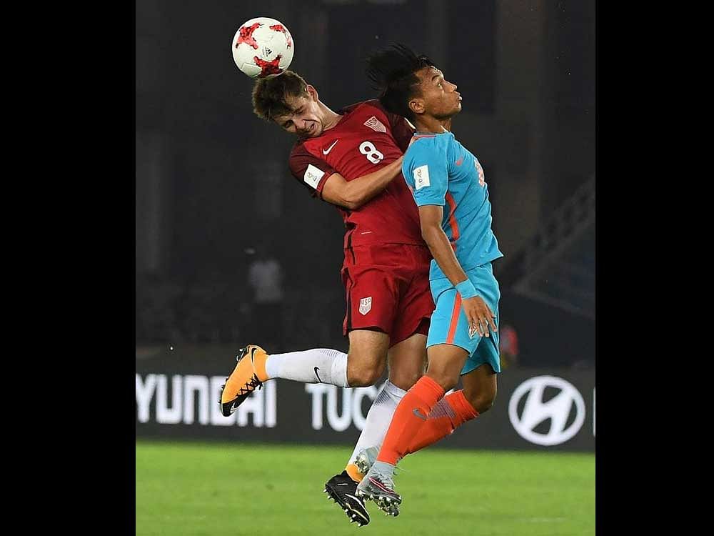 India's captain Amarjit Kiyam (R) and USA's Blaine Ferri jump for ball during the FIFA U-17 World Cup 2017 football match between India and USA at Jawahar Lal Nehru Stadium in New Delhi on October 6, 2017. / AFP PHOTO / PRAKASH SINGH