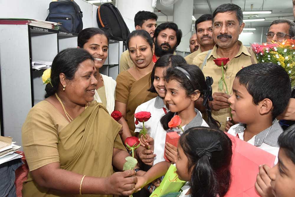 Students from Shanthinikethana school in Girinagar greet postal employees on the occasion of World Post Day at General Post Office in the city on Monday. DH Photo