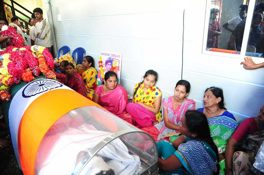 The family of soldier Narendra R mourn beside his body in the city on Tuesday. DH photo