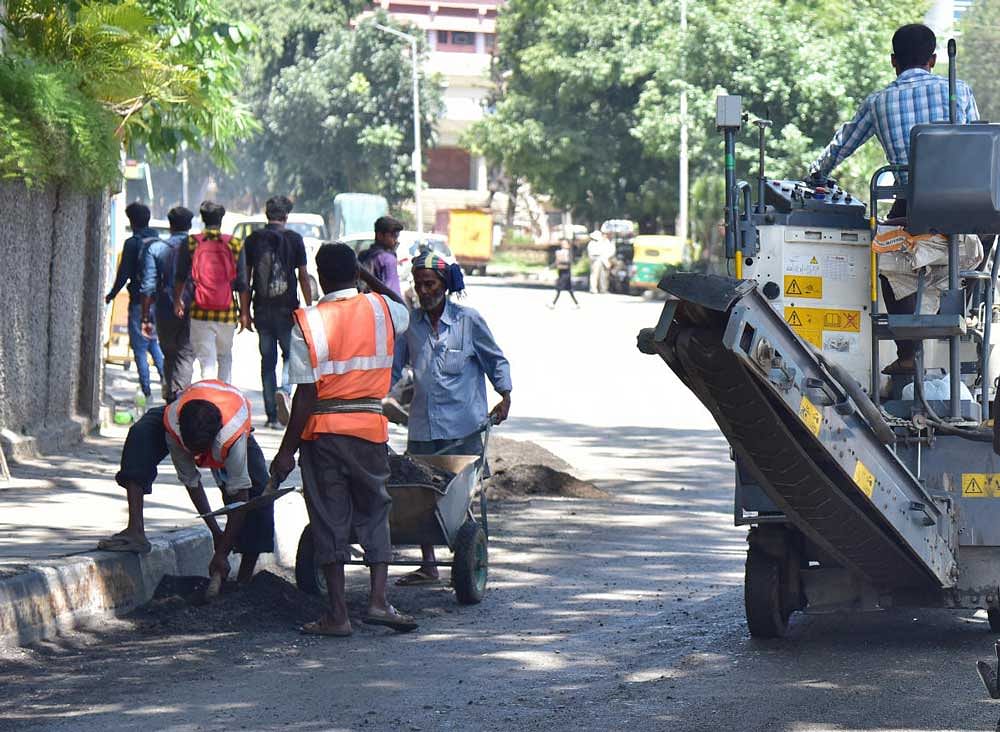 BBMP workers filling potholes at Chalukya Circle on Wednesday. dhphoto