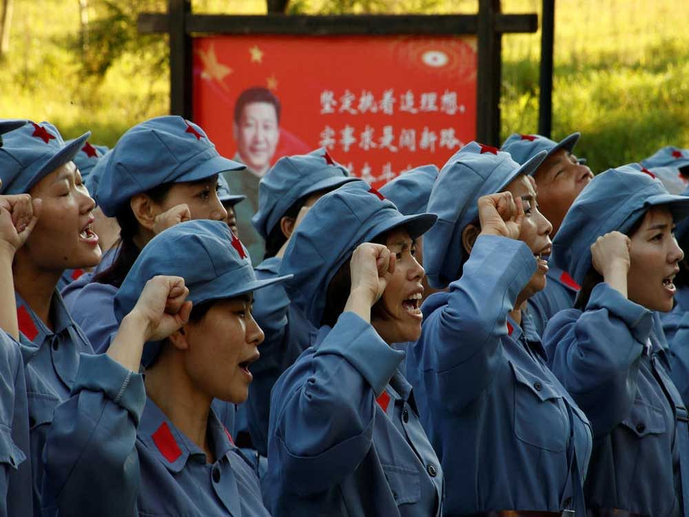 Participants dressed in replica red army uniforms swear an oath during a Communist team-building course extolling the spirit of the Long March in the mountains outside Jinggangshan, Jiangxi province, China, on September 14, 2017.