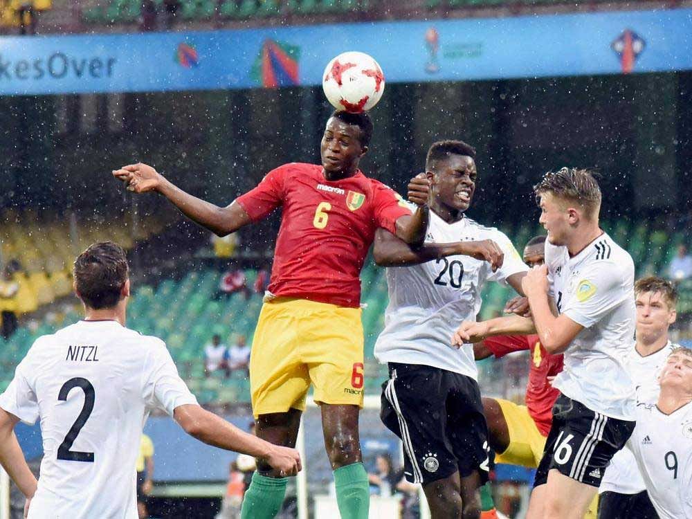 German players attempt to thwart an attack by Guinea in the Under-17 World Cup in Kochi on Friday.  pti