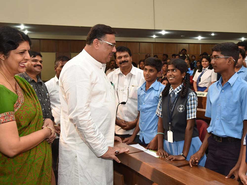 Primary and Secondary Education Minister Tanveer Sait interacts with students at a programme at Vikasa Soudha in Bengaluru on Friday. Dr Kripa Amar Alva, Chairperson, KCPCR, is also seen. dh photo