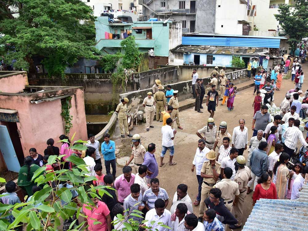 People and police are gathered, where Ningamma and Pushpa (a mother and daughter who are washed away at J C Nagar, Kurubarahalli in storm water drain),Kurubarahalli, in Bengaluru on Saturday. DH Photo