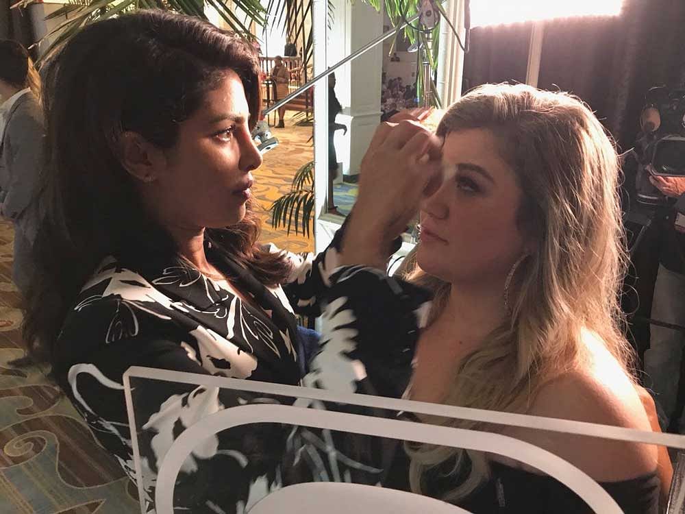 Clarkson, 35, shared a picture with Priyanka on Twitter where the latter can be seen doing the singer's touch-up before she went onstage to deliver her speech. Image courtesy Twitter