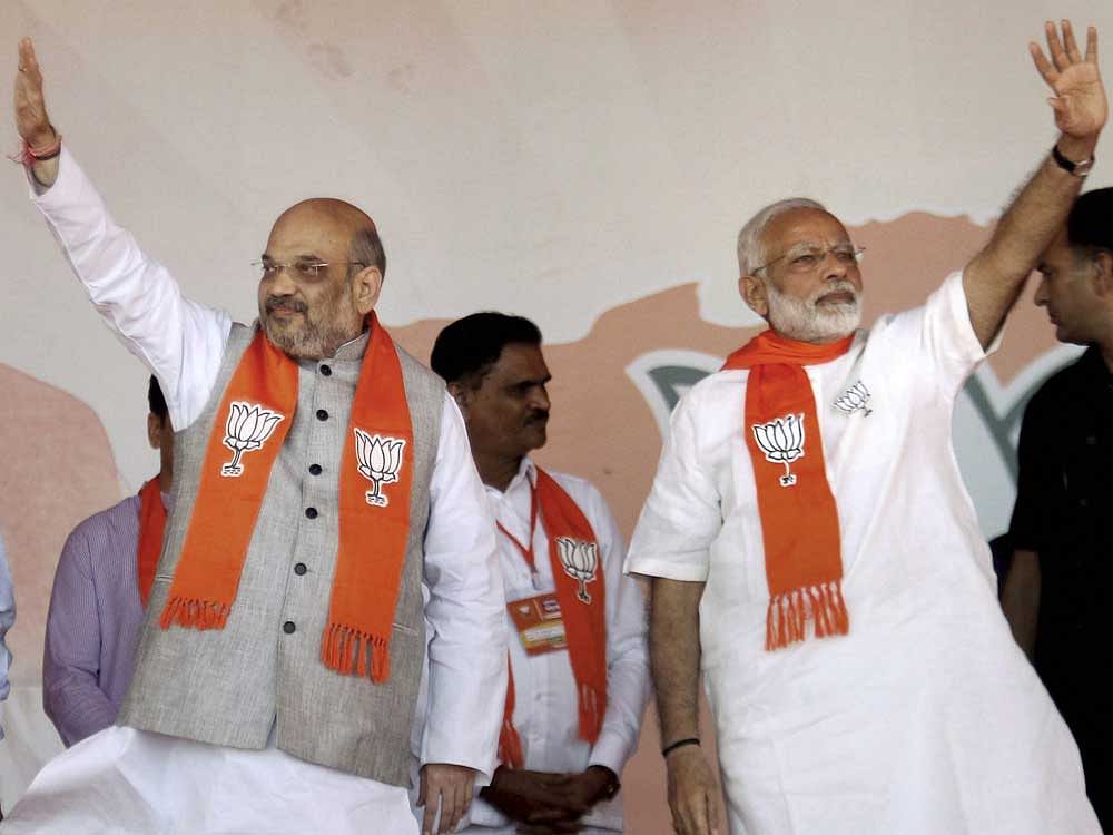 Prime Minister Narendra Modi with BJP President Amit Shah waves at crowd during