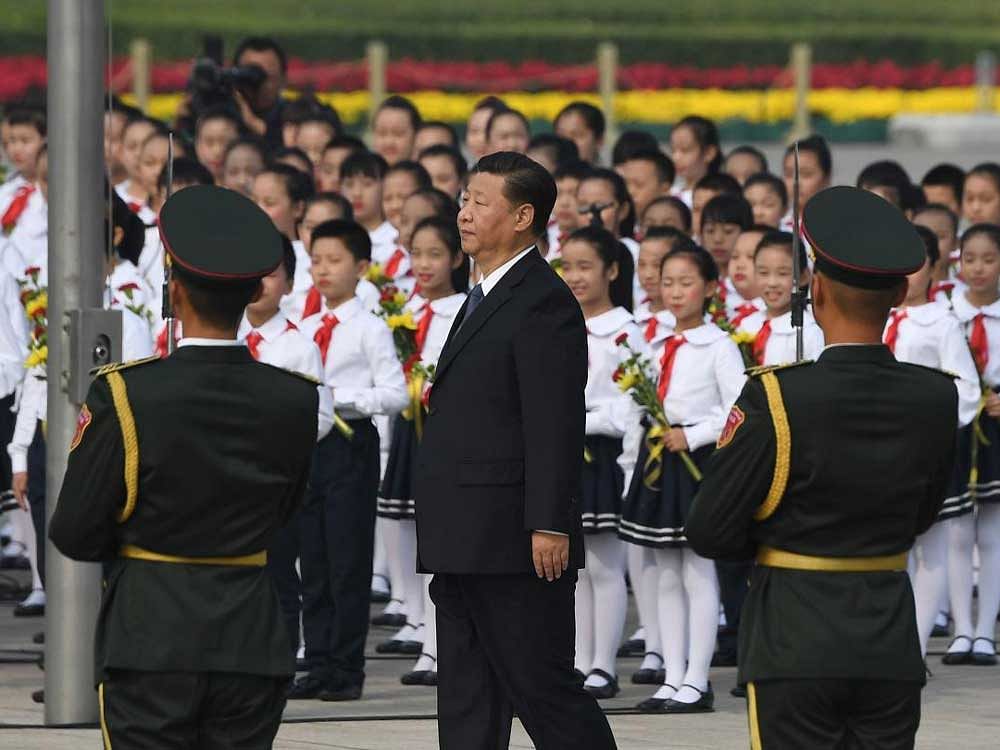 Flag-bearer: Chinese President Xi Jinping at Tiananmen Square on the eve of China's National Day, in Beijing. Many of Xi's plans for the future are underpinned by an idealistic view that it is his mission to lead a rigidly controlled China back to the centre of the world stage. AFP