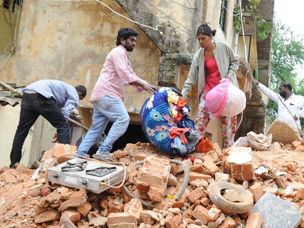 Sathi, one of the eye witness of the building collapse was collecting his bellongings on Tuesday after his house also got damaged due to cylinder blast at Ejipura. DH Photo