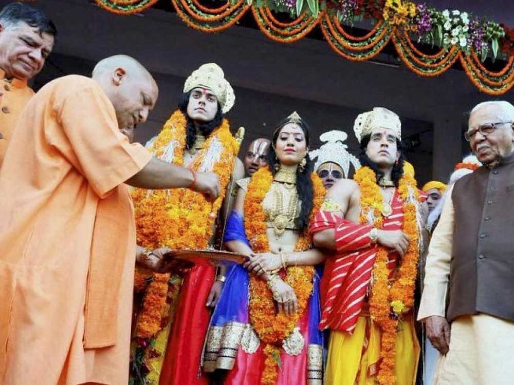 Uttar Pradesh Chief Minister Yogi Adityanath performs 'Abhishek' of artistes dressed up as Lord Rama, Sita and Lakshman during Deepotsav celebrations in Ayodhya on Wednesday. UP Governor Ram Naik is also seen. PTI Photo