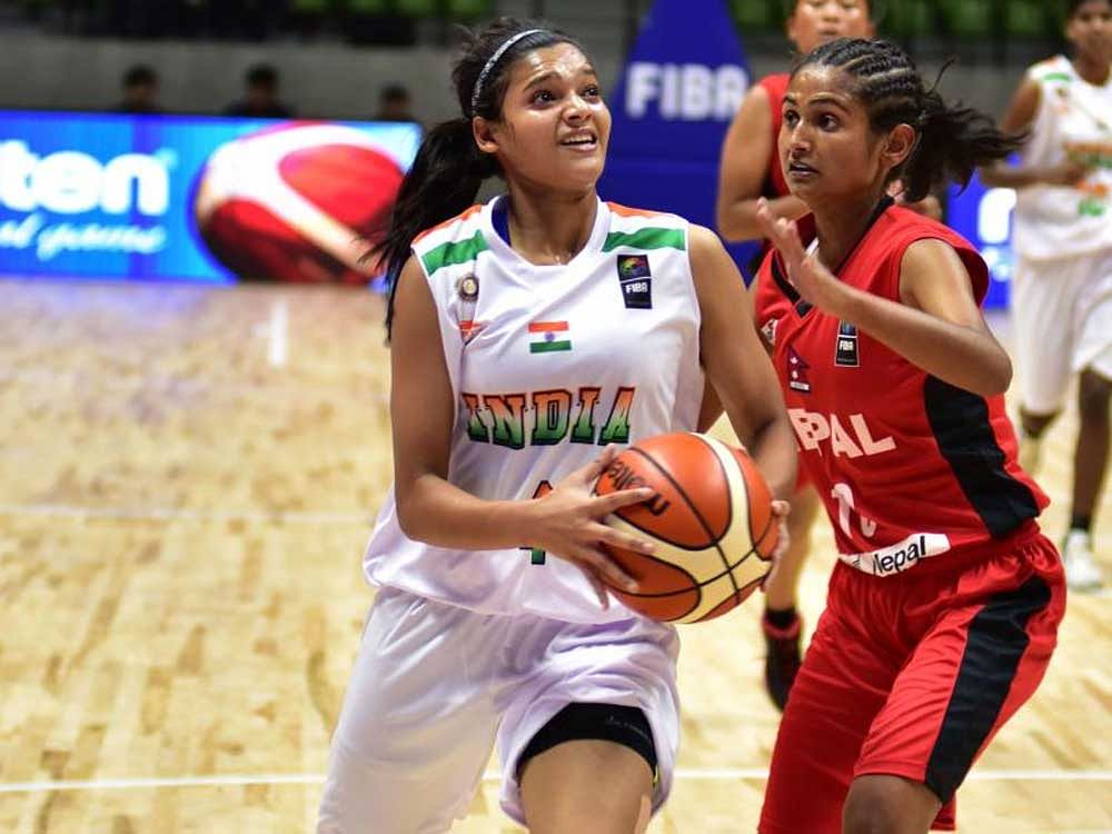 Yadav Vaishn (4, White) of India in action against Nepal in the B division FIBA Women's ASIA Basketball championship at Sree Kanteerava Indoor Stadium in Bengaluru on Sunday. DH