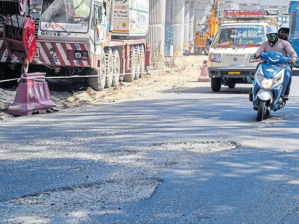 Potholes resurfaced on Sunday on Mysuru Road, between Pantharapalya and the entrance of Rajarajeshwari Nagar, days after the road was repaired following the death of a woman. DH PHOTO/ANAND BAKSHI