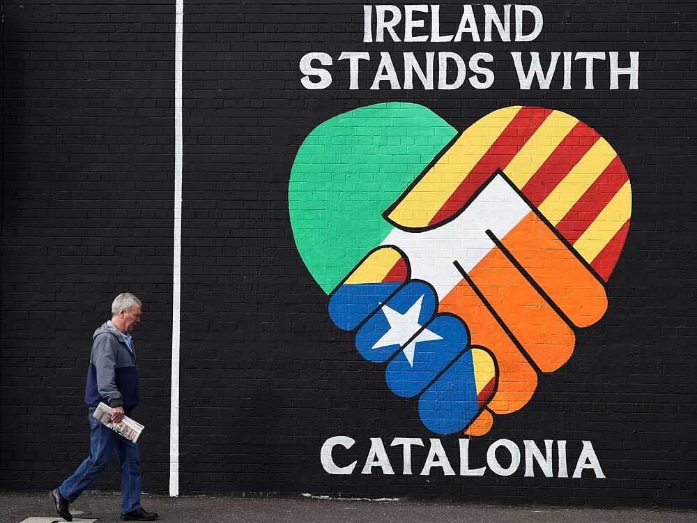 A man walks past a new mural which reads 'Ireland stands with Catalonia' on the Nationalist Falls Road in Belfast, Northern Ireland.  REUTERS Photo