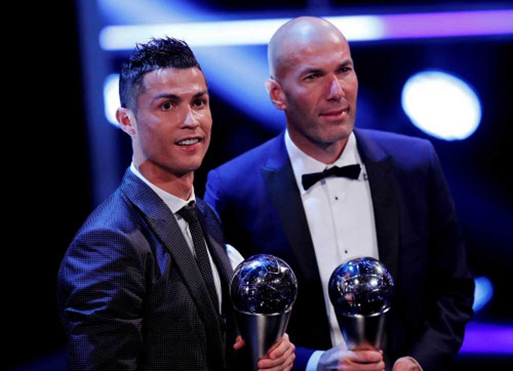 Cristiano Ronaldo celebrates after winning The Best FIFA Men's Player Award with Real Madrid coach Zinedine Zidane. REUTERS