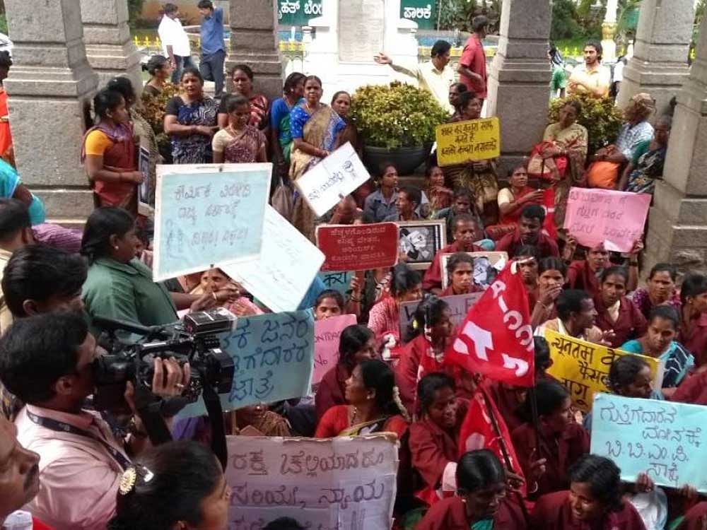 Pourakarmikas stage a protest against the harassment by garbage contractors at the BBMP office on Wednesday. DH photo